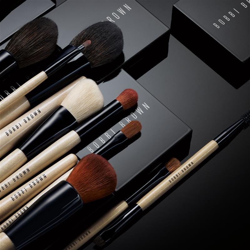 Model applying Skin Long-Wear Weightless Foundation to skin with a foundation brush